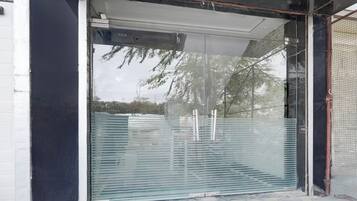 A modern building entrance with a glass door and a metal gate.