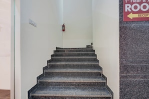 A staircase leading to the 1st floor with a reception sign on the right.