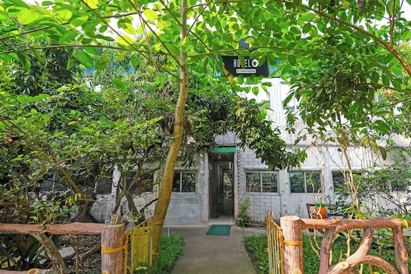 A pathway leading to a building with a sign indicating it is a company-serviced hotel. - Super Hotel O Ranihati Kolkata (Howrah)