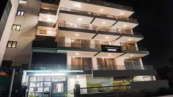 Un edificio de varios pisos con balcones, un letrero que indica que es una casa adosada y una entrada con portón.
