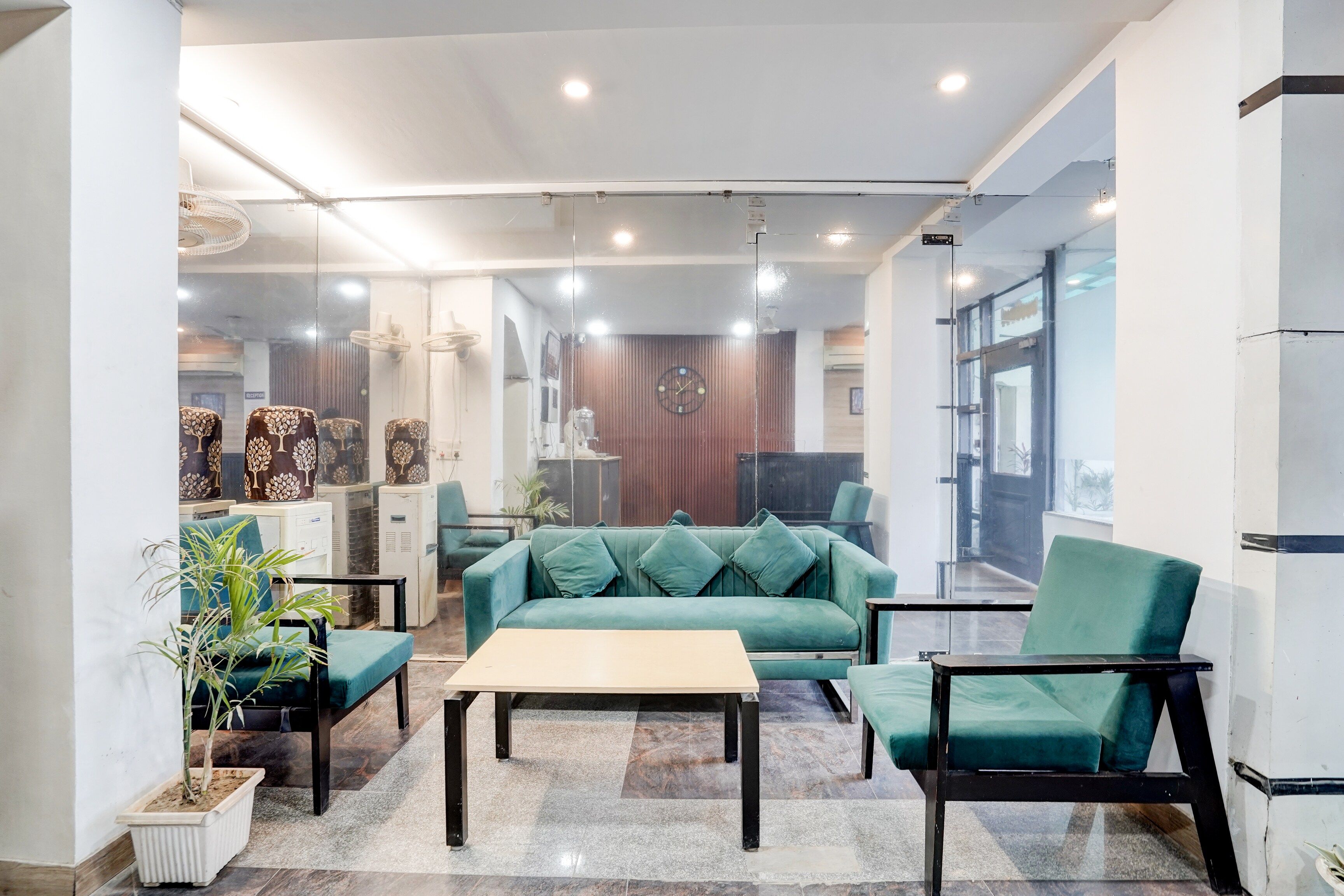 Un interior moderno con un sofá verde, una mesita de centro y una planta en maceta.
