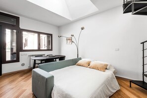 Una camera da letto moderna con un letto, una scrivania e una sedia.