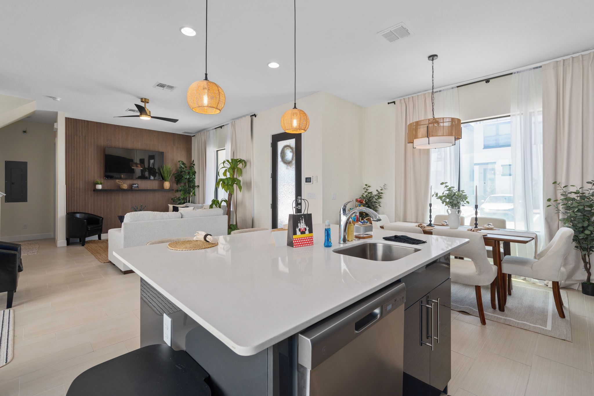 A modern kitchen with a central island, stainless steel appliances, and pendant lighting.