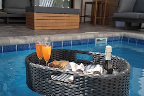 Ein Korbwesen mit Speisen und Getränken am Pool.