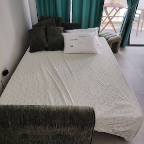 A bed with a white duvet, a pillow, and a blanket. - Charming Bayahíbe Apartment Comfort Pool, Beach Access (San Rafael del Yuma)