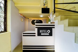 A hotel reception desk with a sign indicating it is company-serviced.
