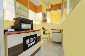 A hotel reception area with a clock, a desk, a chair, and a sign indicating the hotel name. - Hotel O Narsampathi Lakeview Coimbatore (Coimbatore)
