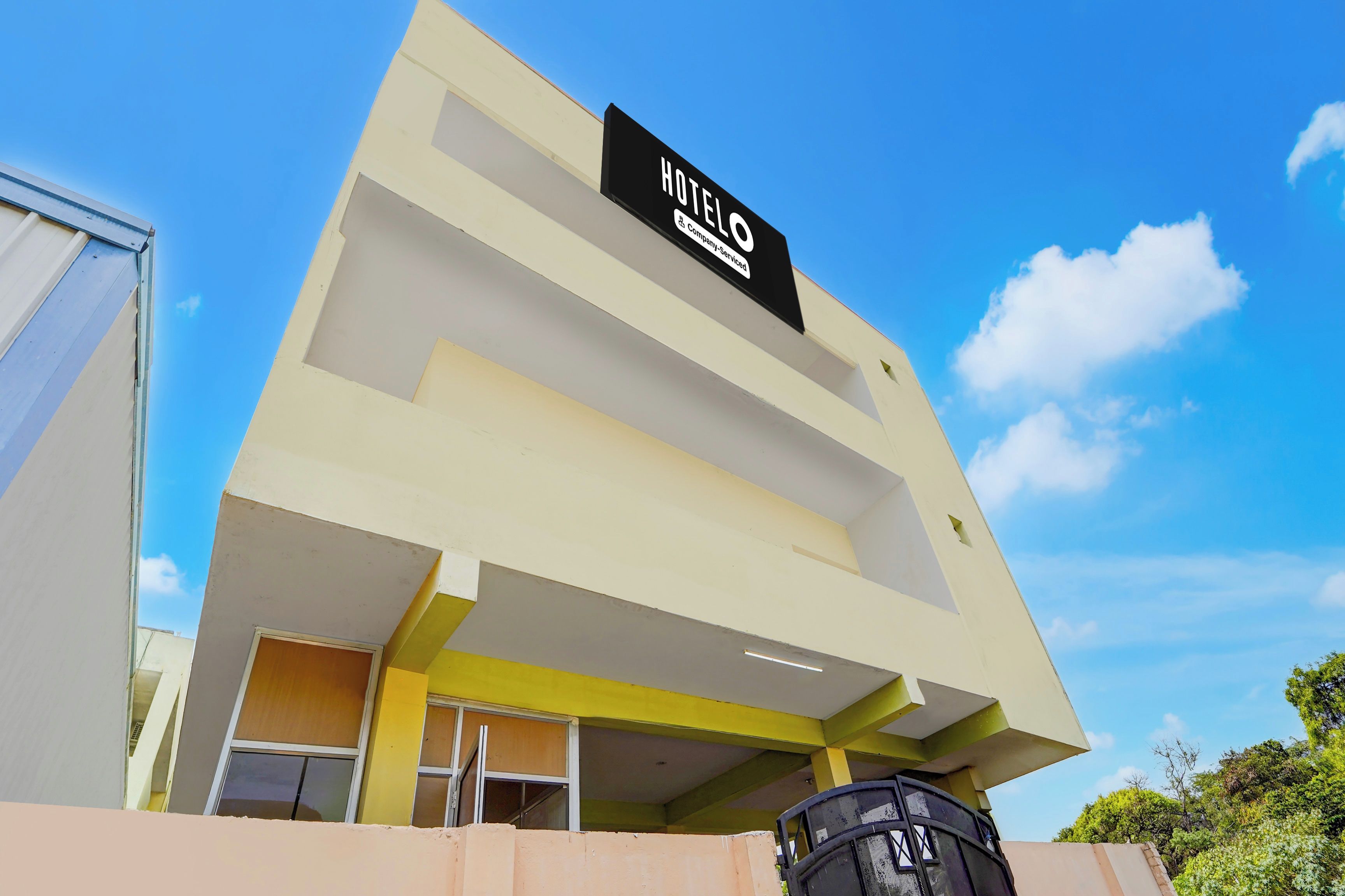 A hotel building with a sign indicating it is a company-serviced hotel.
