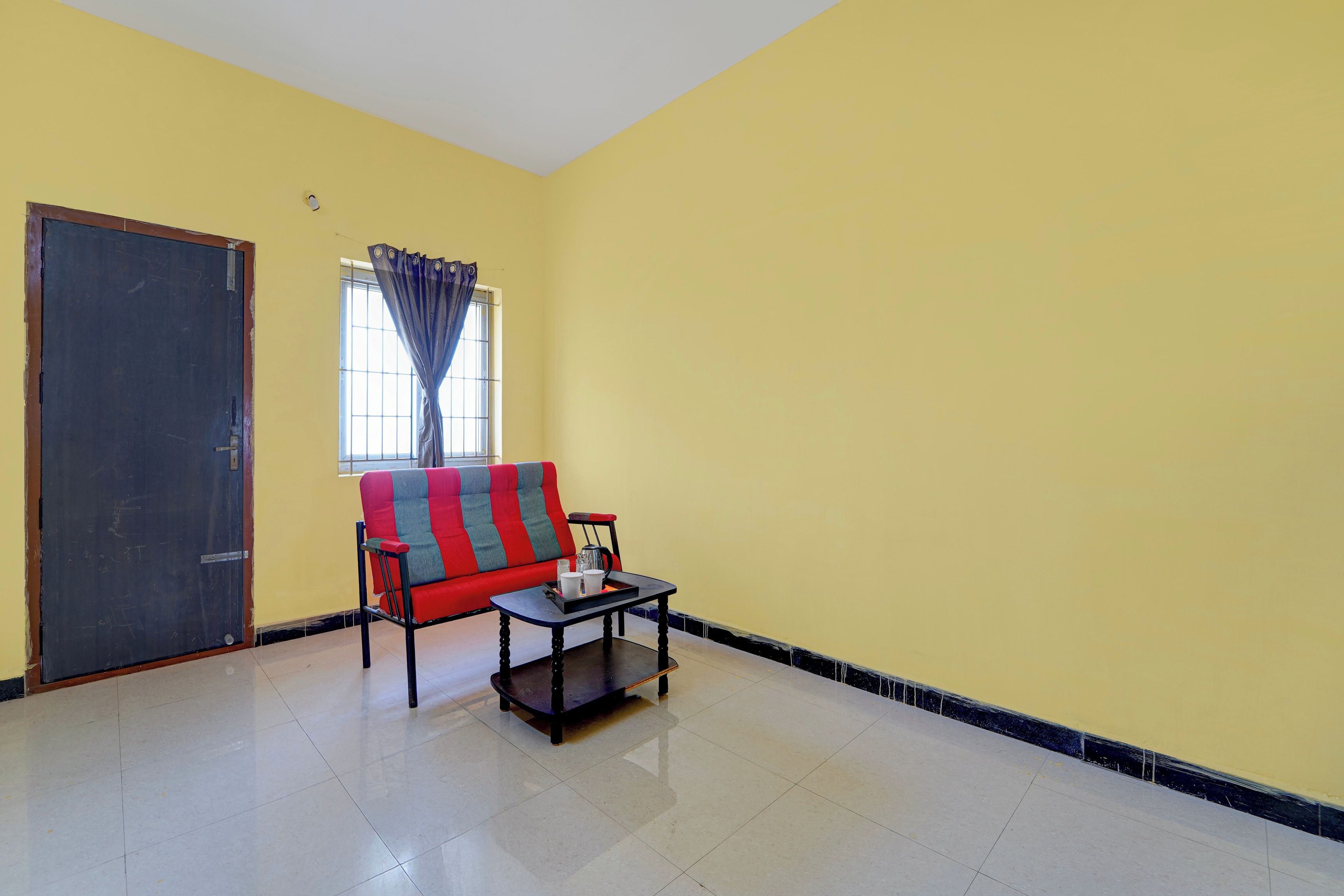 Una habitación con sofá, una mesa de centro y una puerta.