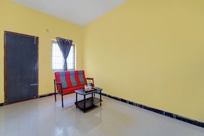 A room with a sofa, a coffee table, and a door. - Hotel O Narsampathi Lakeview Coimbatore (Coimbatore)