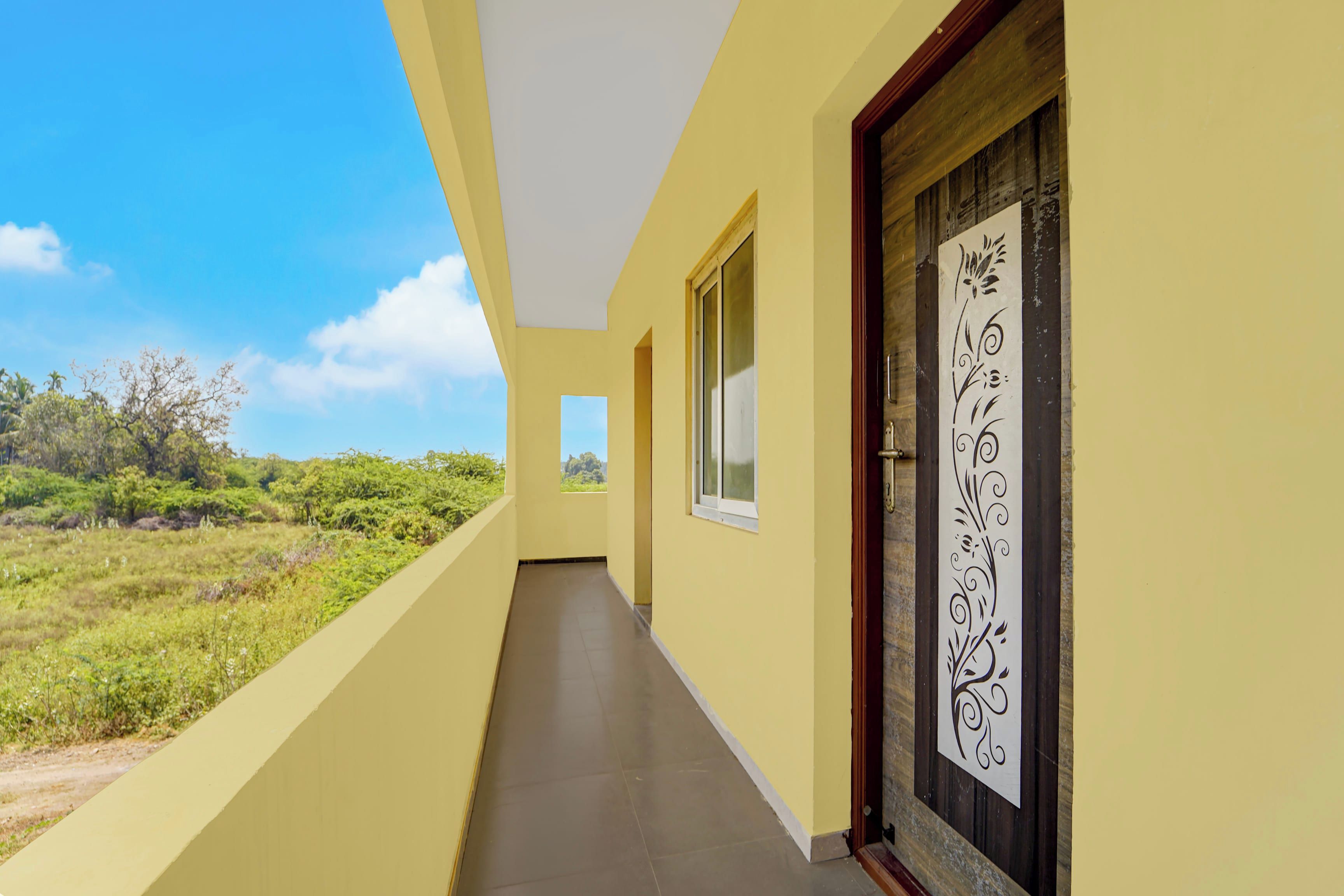 Un pasillo con vistas a zonas verdes y una puerta con un panel decorativo.