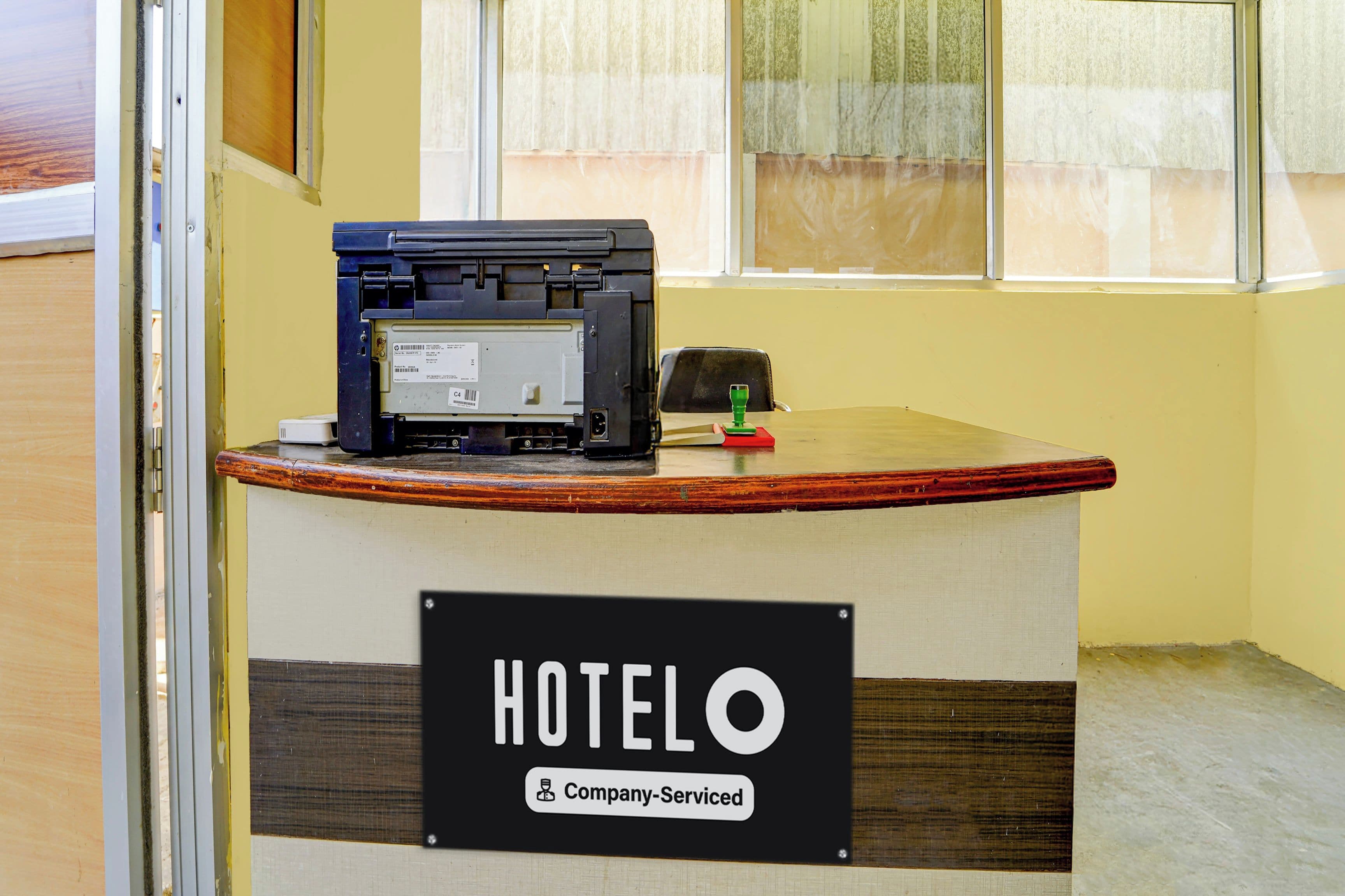A reception desk with a sign indicating 'HOTELO & Company Serviced'.