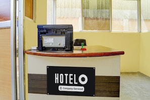 A reception desk with a sign indicating 'HOTELO & Company Serviced'.