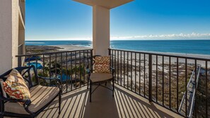 A balcony with a view of the beach and ocean, furnished with two chairs and a table. - Phoenix East 605 1 Bedroom Condo (Orange Beach)