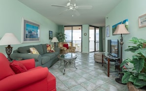 A living room with a sofa, armchair, and a glass coffee table. - Phoenix East 602 1 Bedroom Condo (Orange Beach)