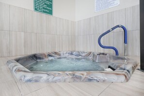 A hot tub with a marble-like interior, a blue hose, and a sign with instructions. - Phoenix Ii 2141 3 Bedroom Condo (Orange Beach)