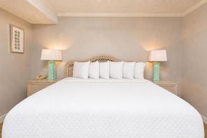 A hotel room with a large bed, two bedside tables with lamps, and a wall-mounted telephone. - Phoenix East 408 1 Bedroom Condo (Orange Beach)