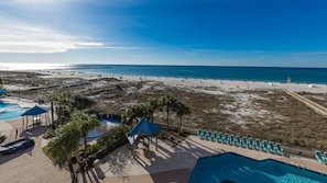 A beach resort with a pool area, lounge chairs, and a view of the ocean. - Phoenix East 408 1 Bedroom Condo (Orange Beach)