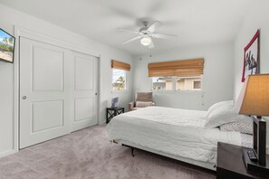 A bedroom with a bed, a ceiling fan, a window with blinds, a chair, and a desk with a lamp. - Na Hale O Keauhou#N6: Beautiful Corner Townhome with Ac! (Kailua Kona)