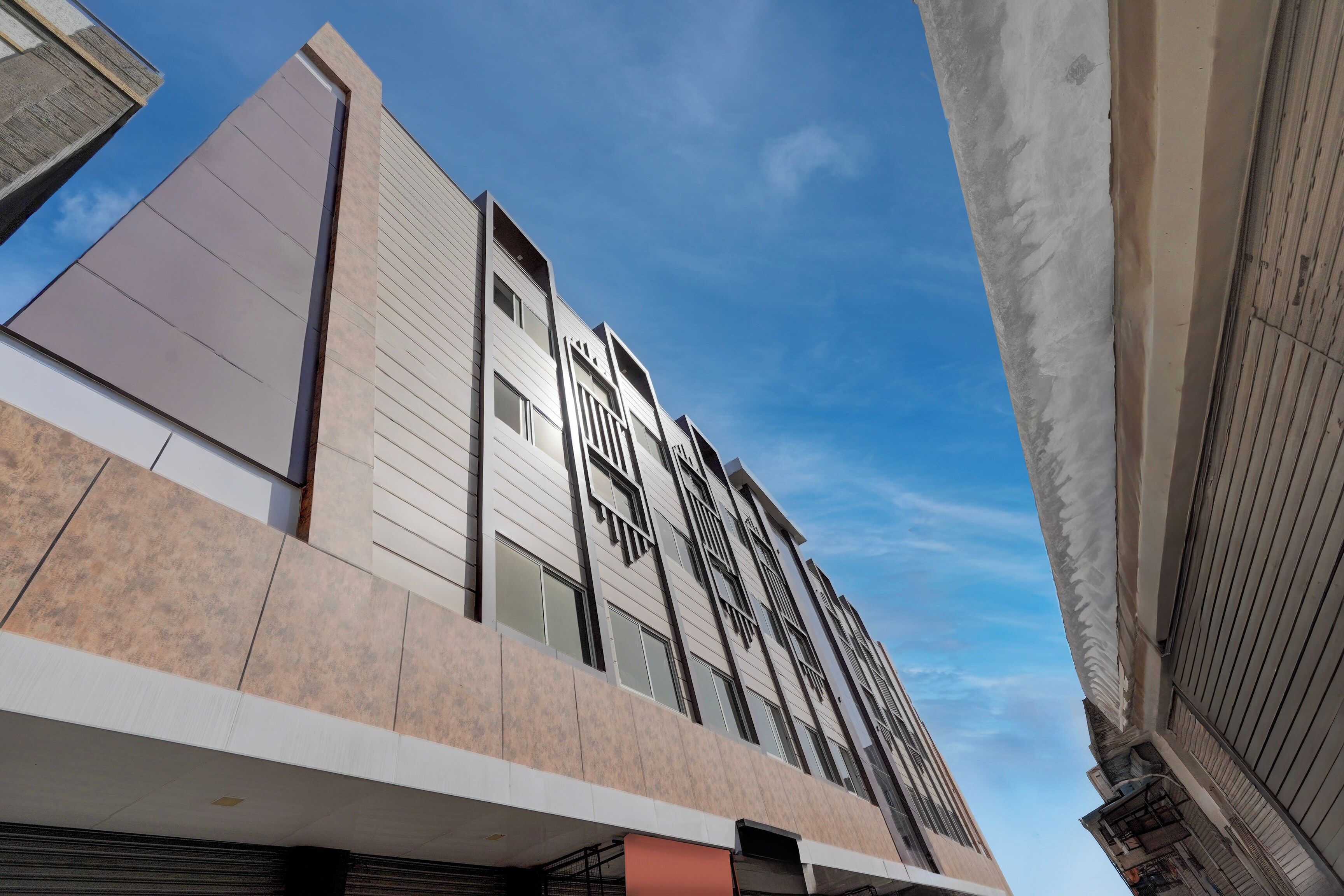 Un edificio moderno con una vista destacada desde la esquina, que presenta una combinación de líneas horizontales y verticales en su arquitectura.