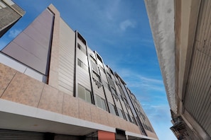 A modern building with a prominent corner view, featuring a mix of horizontal and vertical lines in the architecture.