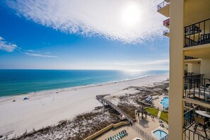 A beach view with a pool area and a building with balconies. - Phoenix Ii 2098 3 Bedroom Condo (Orange Beach)