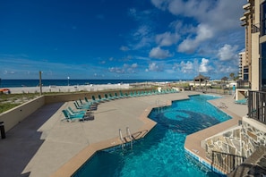 A pool area with lounge chairs and a view of the beach. - Phoenix Ii 2098 3 Bedroom Condo (Orange Beach)