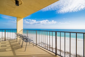 A beachside balcony with a view of the ocean, equipped with metal chairs and a railing. - Phoenix Ii 2098 3 Bedroom Condo (Orange Beach)