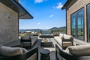 A modern outdoor seating area with a flat-screen TV, sofas, and a fire pit. - 4br Deer Valley Home With Hot Tub, Sauna & Views 4 Bedroom Home (Heber City)