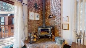 A cozy room with a brick fireplace, a wooden bench, and a rustic decor. - Meadow Ridge #8 3 Bedroom Condo (Mammoth Lakes)