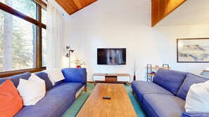 A modern living room with two sofas, a coffee table, a TV, and a painting on the wall. - Meadow Ridge #8 3 Bedroom Condo (Mammoth Lakes)