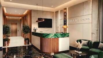 Een moderne hotellobby met een receptiebalie, een zithoek en een incheckbalie.