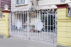 A gated entrance with ornate metalwork, a sign indicating a business or office, and a potted plant. - Super Collection O Jyotirindra Nandi (Kolkata)