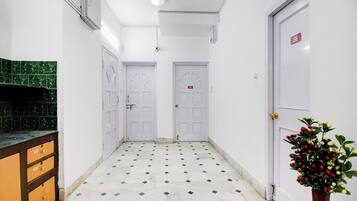 A hallway with white doors, a tiled floor, and a green-tiled backsplash.