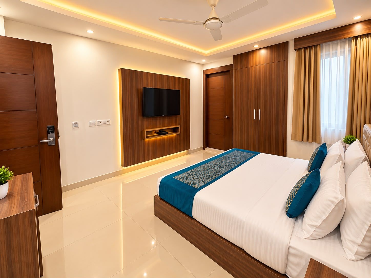 A modern hotel room with a large bed, wooden wardrobe, a flat-screen TV, and a ceiling fan.