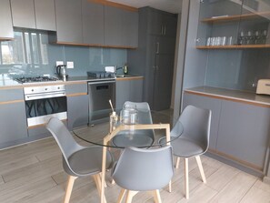A modern kitchen with a dining area. - Luxurious 2-bedroom Apartment in Umhlanga, South Africa (uMhlanga)