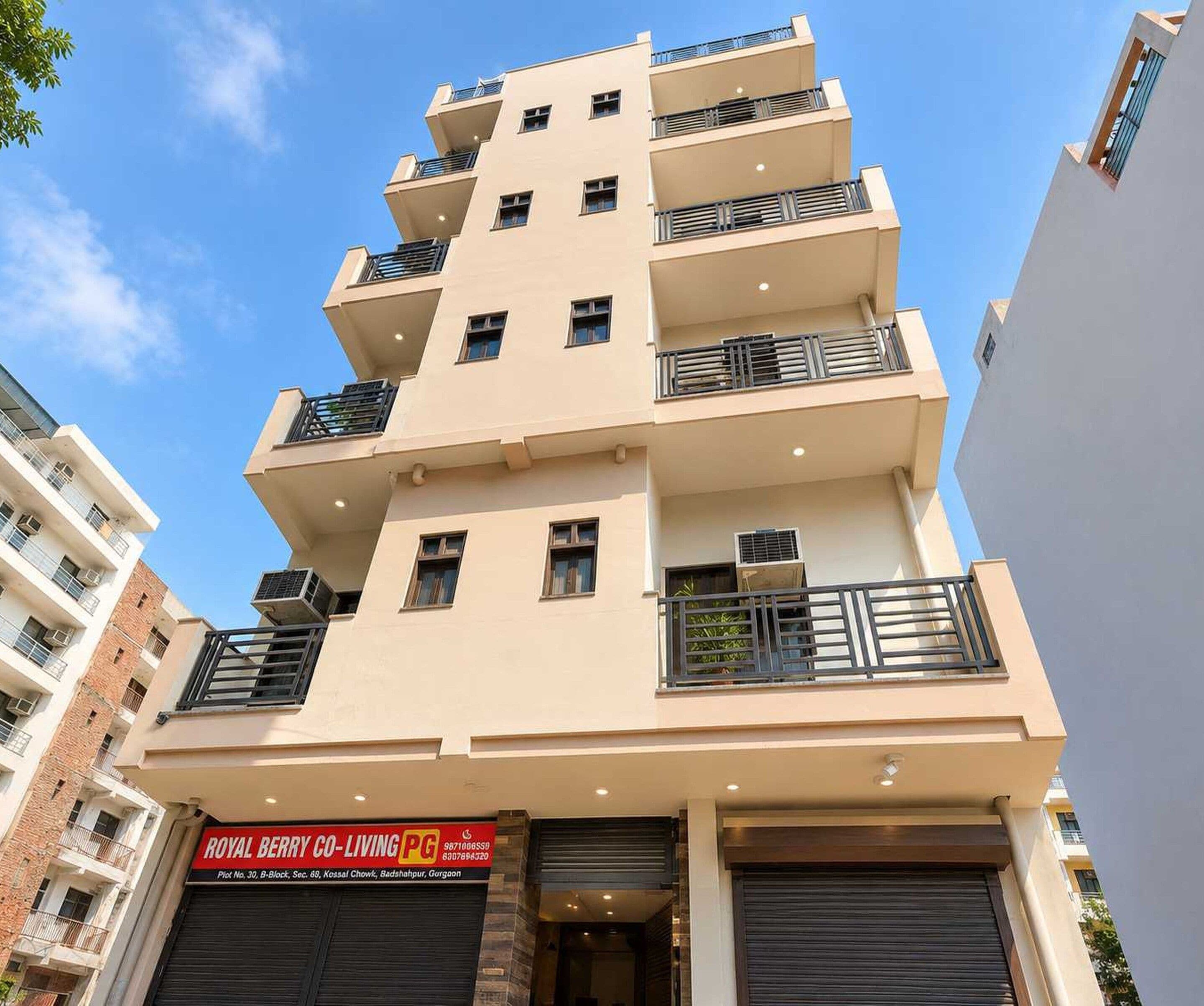 A multi-story residential building with balconies, air conditioning units, and a visible commercial sign on the ground floor.
