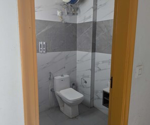 A bathroom with a toilet, a shower, and a sink. - Luxury Hotel O 69 (Gurugram)
