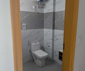 A bathroom with a toilet, a shower, and a sink. - Luxury Hotel O 69 (Gurugram)
