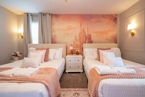 Habitación de hotel con dos camas, una mesita de noche, una lámpara y un mural grande en la pared.