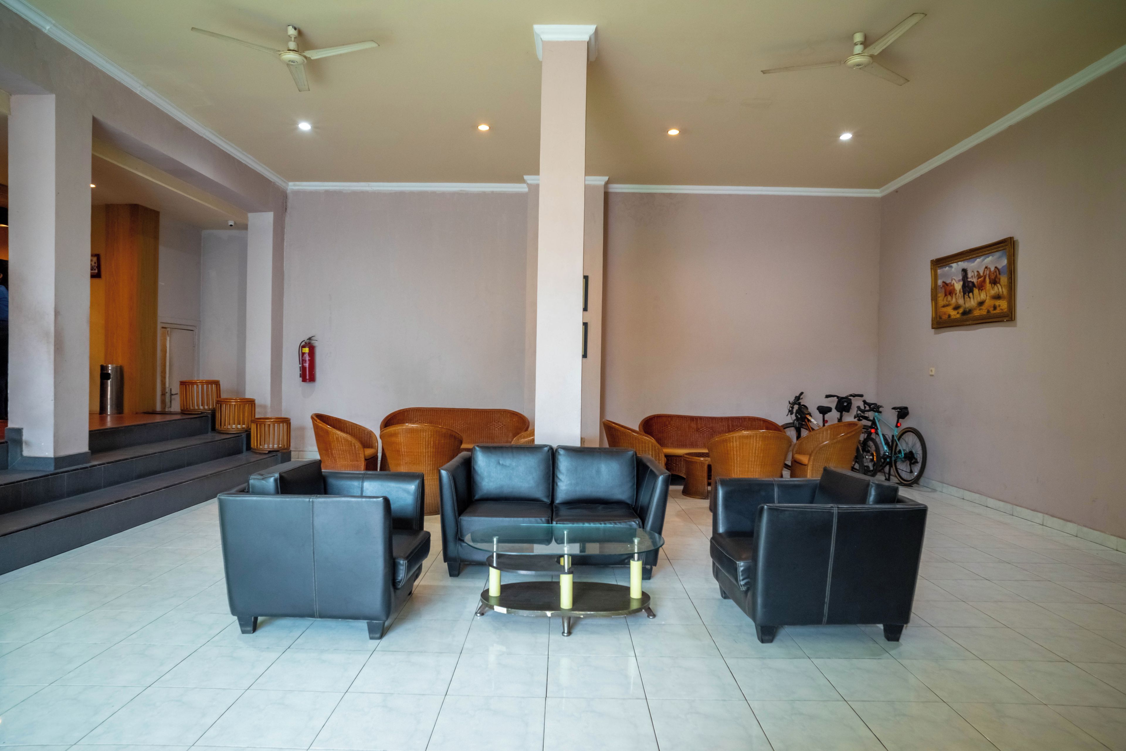 A lobby with a seating area, a staircase, and a fire extinguisher.