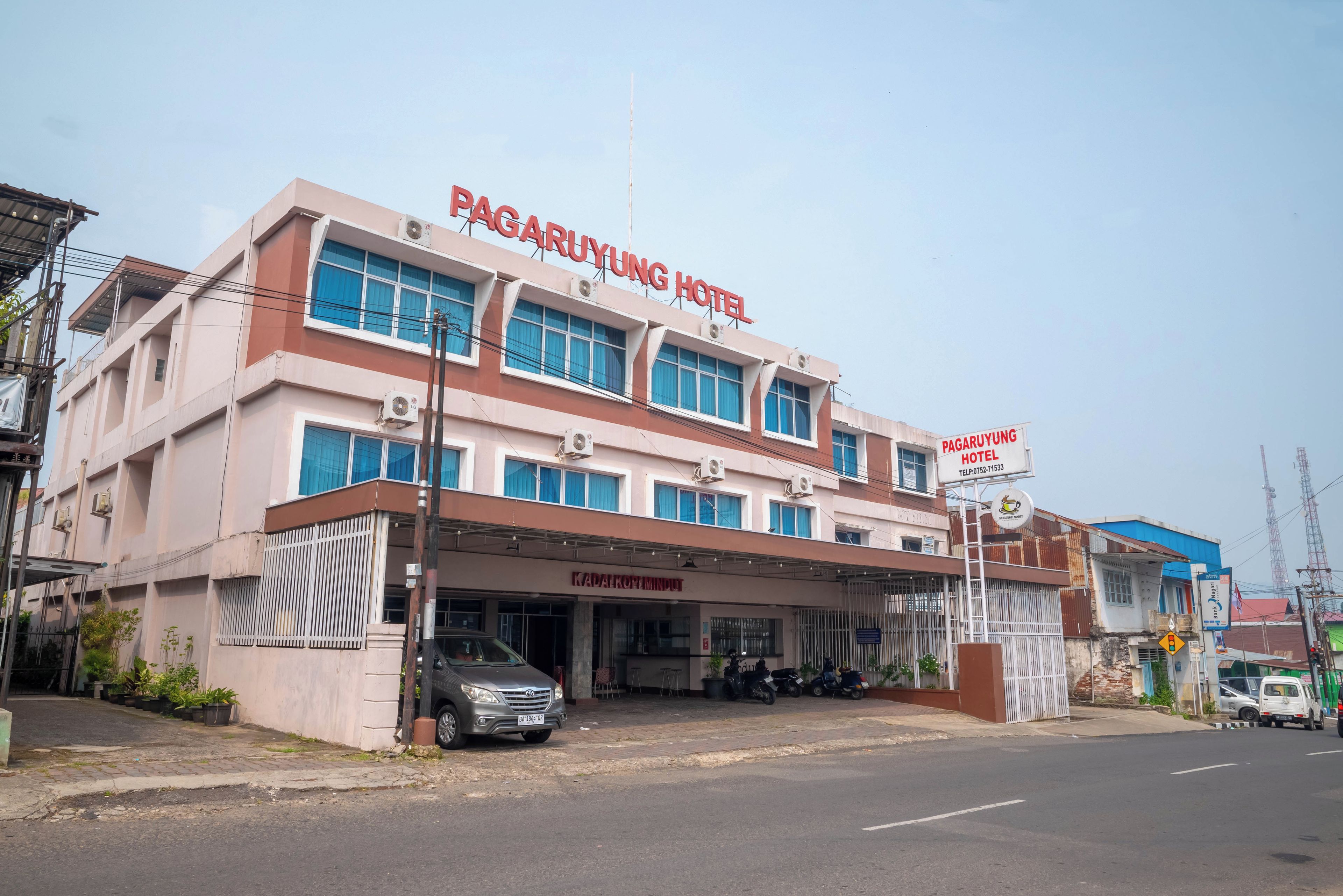 A hotel with a sign reading 'PAGARUYUNG HOTEL' and a visible entrance with a car parked outside.