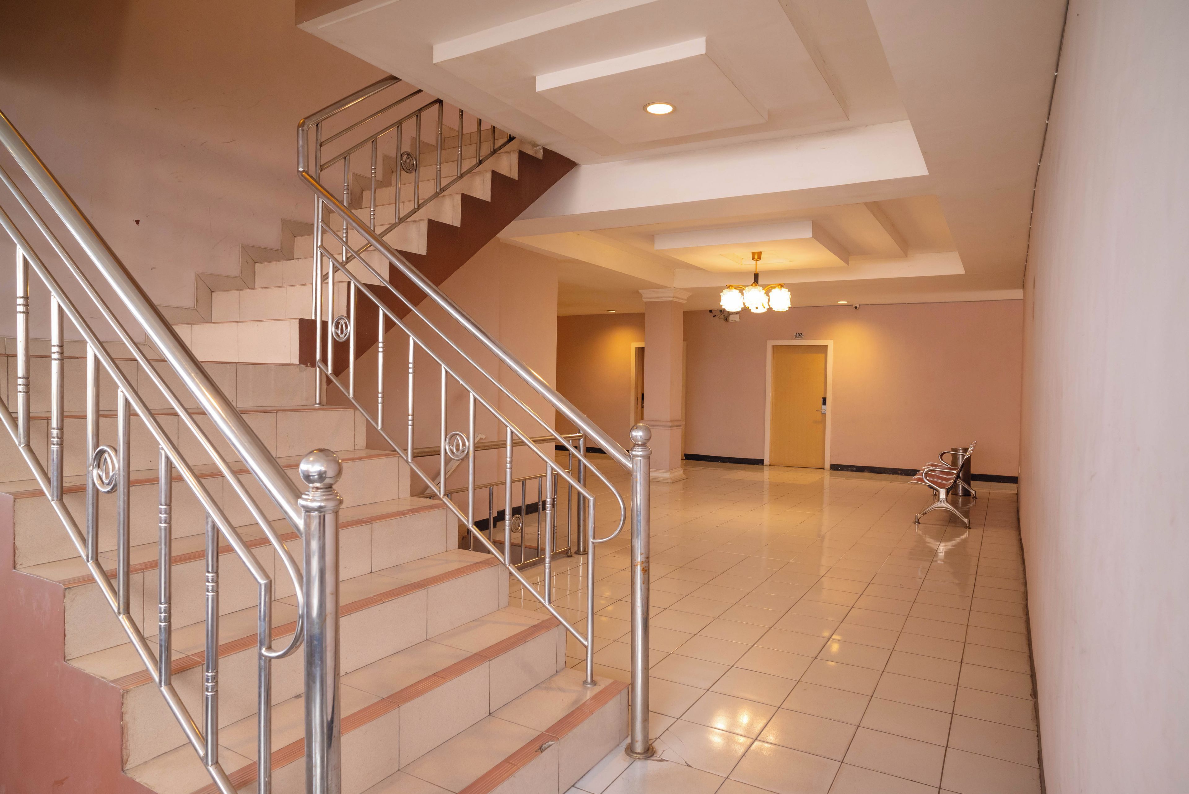 A spacious interior with a staircase, a chandelier, and a bench.