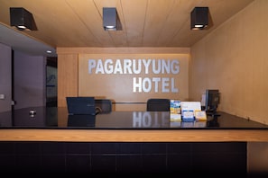 A reception desk with a wooden panel wall, a sign reading 'PAGARUYUNG HOTEL', and a calendar for November 2026.