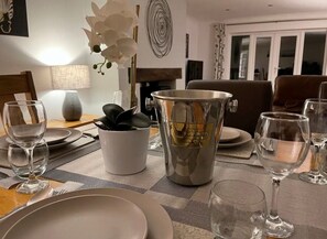 A dining table set with plates, glasses, and a decorative pitcher. - Cornwall Holiday Home with hot tub and acre of garden (Saltash)