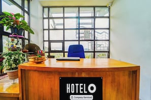 Un mostrador de recepción de hotel con un cartel que dice 'HOTELO' y 'Servicio para empresas'.