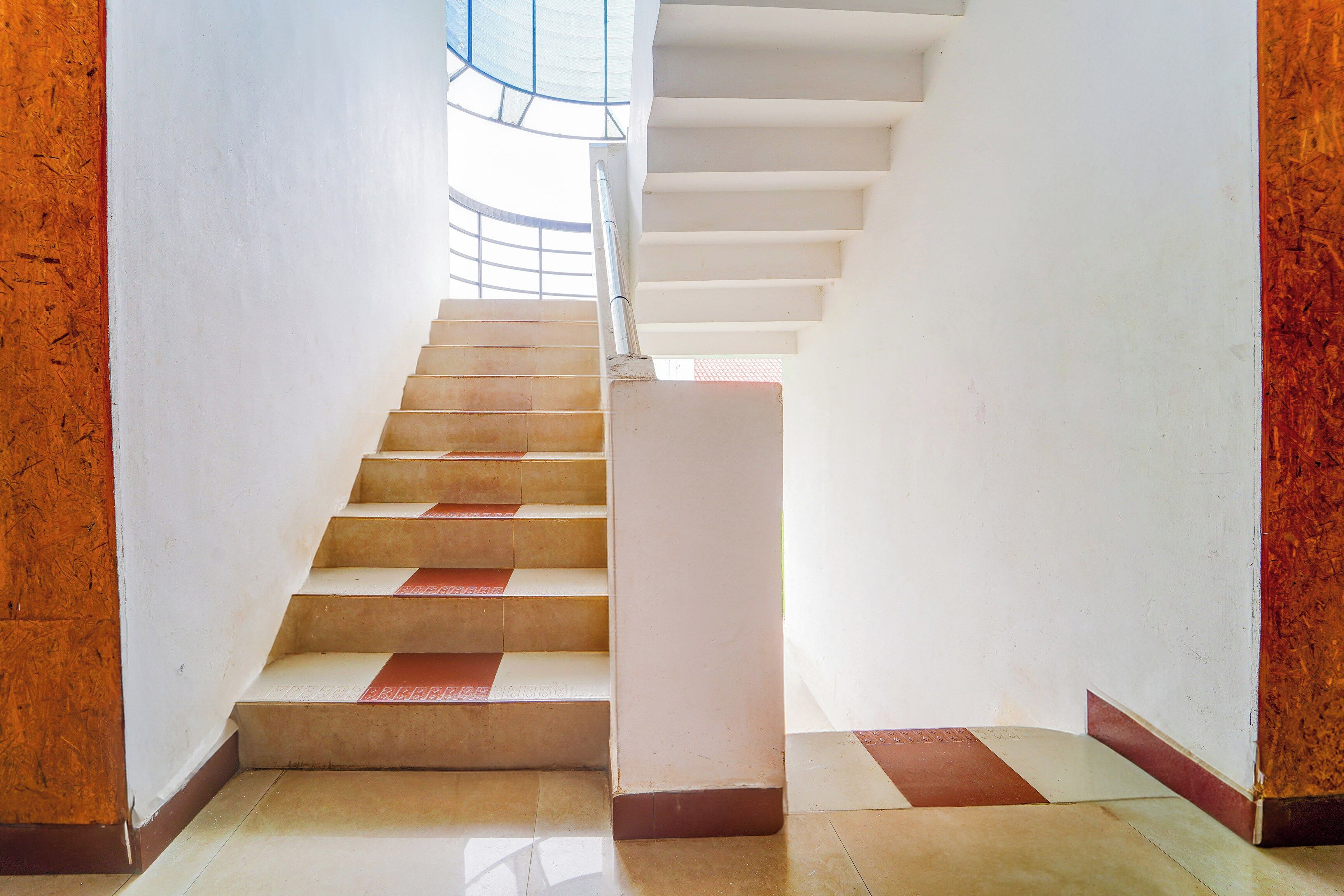 A staircase with a handrail, leading to a higher floor.