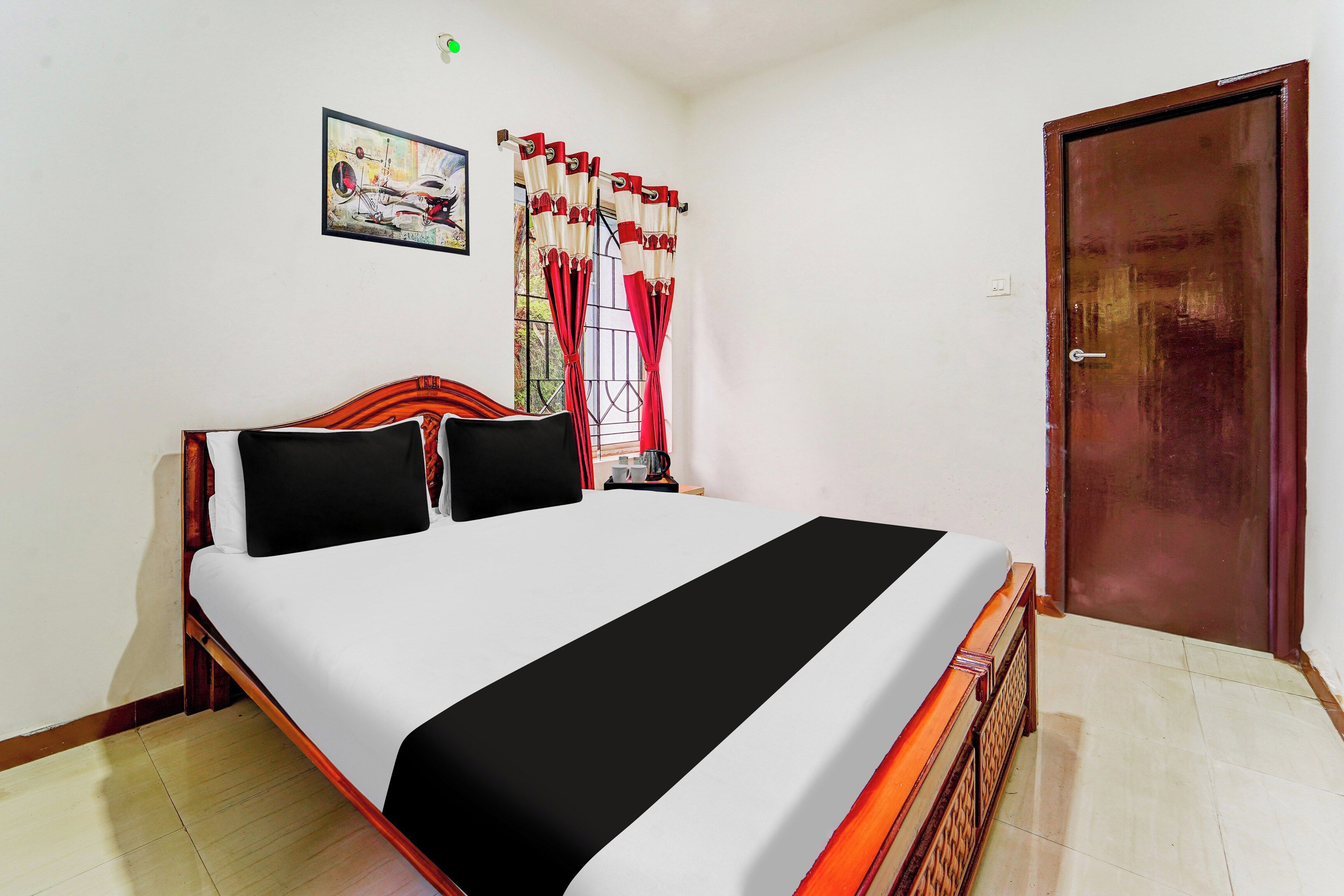 A room with a bed, a door, and a window with curtains.