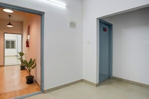 Un passadís amb una porta que porta el número '301' i una planta en test.