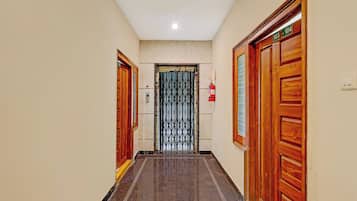 Un pasillo con puertas de madera, un extintor y un cartel con la indicación de las habitaciones 103-104.